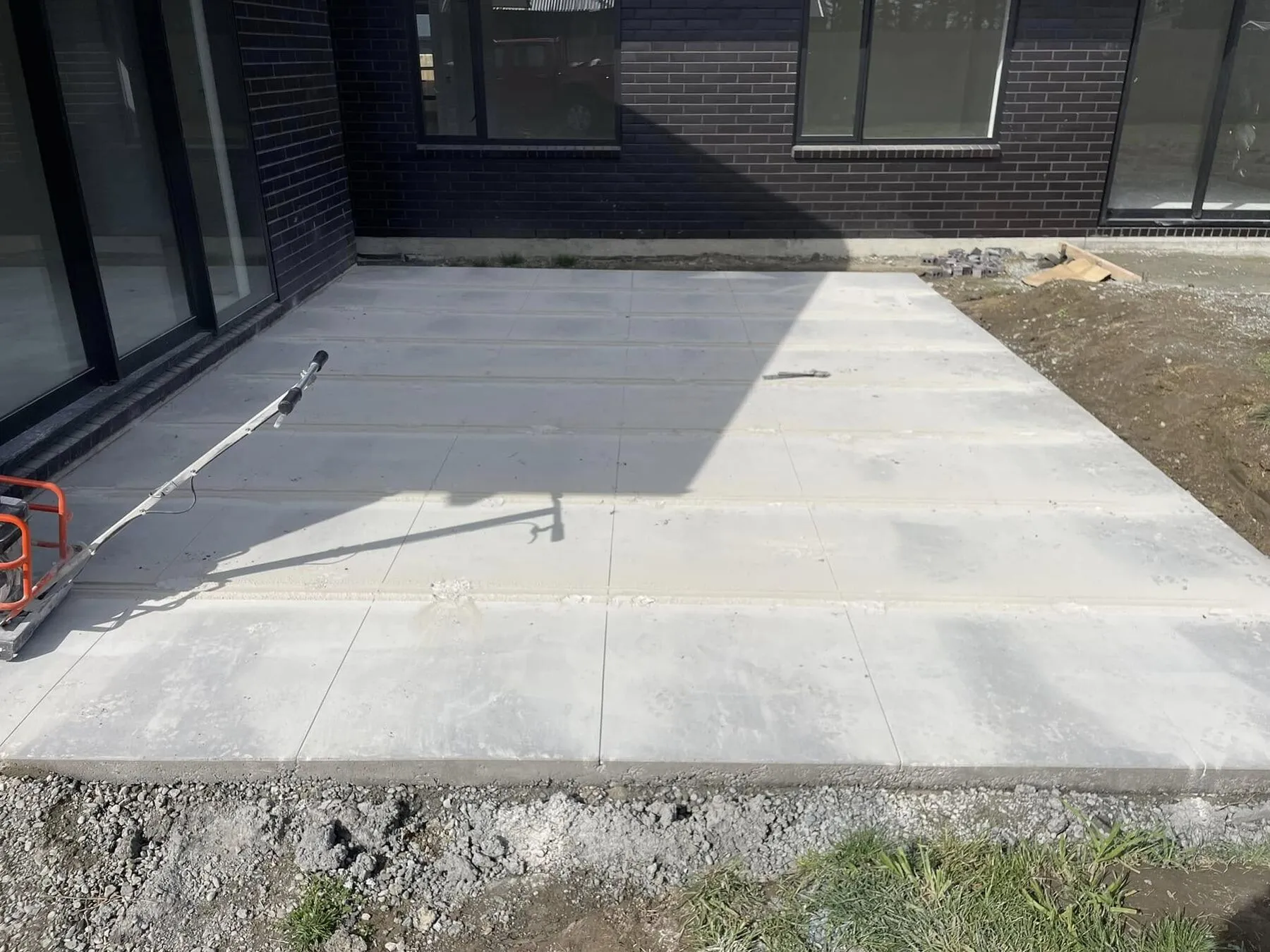 Soft cut saw at the edge of a patio with the first decorative lines cut across the slab